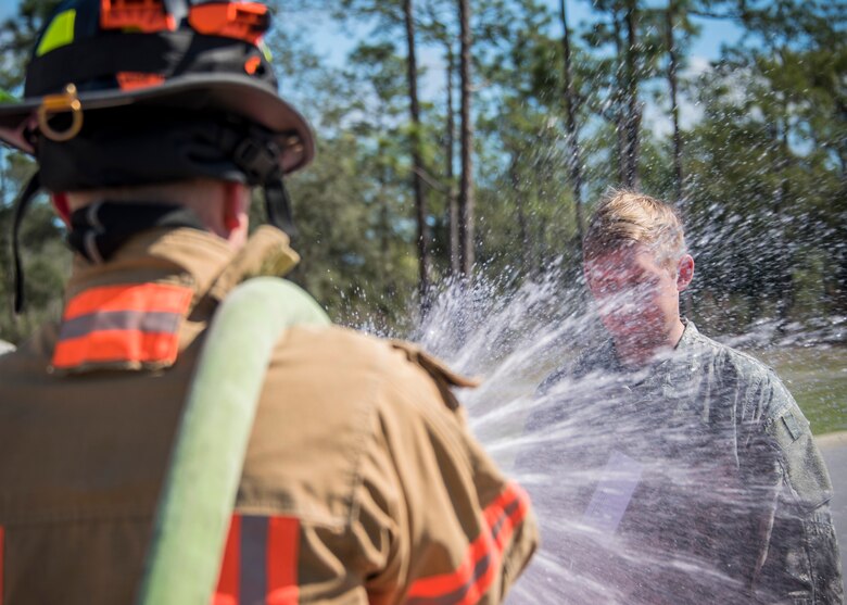 A firefighter with the 96th Civil Engineer Group, sprays water on a U.S. Army 7th Special Forces Group (A) participant to simulate decontamination processes Feb. 23 during an exercise at Eglin Air Force Base, Fla. The simulated detonation scenario tested firefighters, security forces and medical emergency response personnel agencies among others. (U.S. Air Force photo/Ilka Cole) 