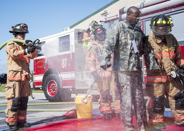 A firefighter with the 96th Civil Engineer Group, sprays water on a U.S. Army 7th Special Forces Group (A) participant to simulate decontamination processes Feb. 23 during an exercise at Eglin Air Force Base, Fla. The simulated detonation scenario tested firefighters, security forces and medical emergency response personnel agencies among others. (U.S. Air Force photo/Ilka Cole) 