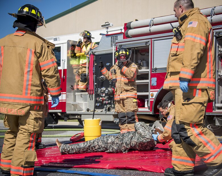 Firefighters with the 96th Civil Engineer Group, stabilize a U.S. Army 7th Special Forces Group (A) participant after a simulated decontamination process Feb. 23 during an exercise at Eglin Air Force Base, Fla. The simulated detonation scenario tested firefighters, security forces and medical emergency response personnel agencies among others. (U.S. Air Force photo/Ilka Cole) 