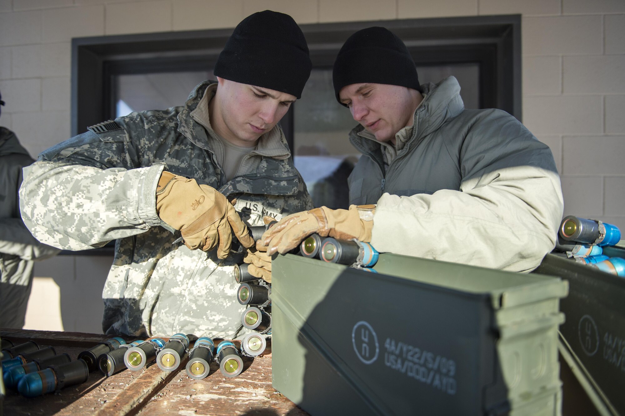 Paratroopers assigned to Dog Company, 3rd Battalion, 509th Parachute Infantry Regiment, 4th Infantry Brigade Combat Team (Airborne), 25th Infantry Division, U.S. Army Alaska, prepare to issue practice 40 mm grenade ammunition before conducting live-fire machine gun training at Grezelka range, Joint Base Elmendorf-Richardson, Alaska, Feb. 28, 2017. The paratroopers practiced engaging targets at varying distances utilizing the M240B machine gun and the Mark 19 40 mm grenade machine gun. (U.S. Air Force photo/Alejandro Pena)