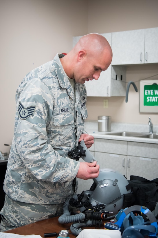 Staff Sgt. Justin Necaise, 403rd Operations Support Squadron survival technician attaches night vision goggles to a flight helmet Feb. 22 at Keesler Air Force Base, Mississippi. (U.S. Air Force photo/Staff Sgt. Heather Heiney) 