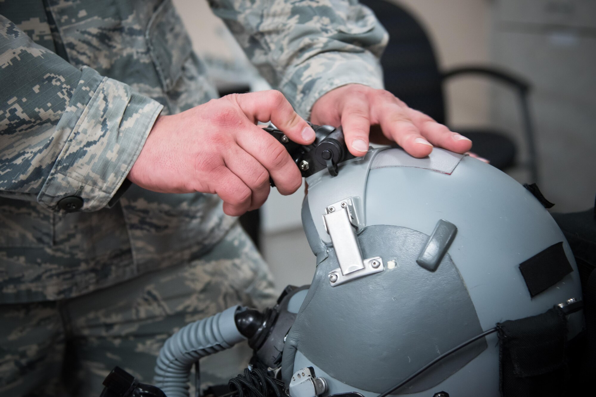 Staff Sgt. Justin Necaise, 403rd Operations Support Squadron survival technician attaches night vision goggles to a flight helmet Feb. 22 at Keesler Air Force Base, Mississippi. (U.S. Air Force photo/Staff Sgt. Heather Heiney)