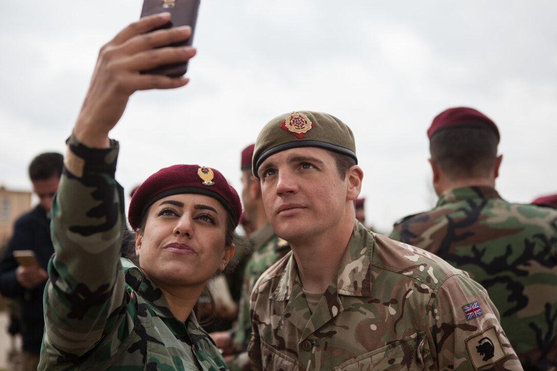 A Zeravani soldier takes a selfie with a British trainers after her graduation ceremony near Erbil, Iraq, Feb. 16, 2017. The training, which included movement on urban terrain, basic marksmanship, vehicle search and other soldier skills, is part of the overall Combined Joint Task Force – Operation Inherent Resolve building partner capacity by training and improving the capability of partnered forces fighting ISIS. CJTF-OIR is the global Coalition to defeat ISIS in Iraq and Syria. (U.S. Army photo by Sgt. Josephine Carlson)