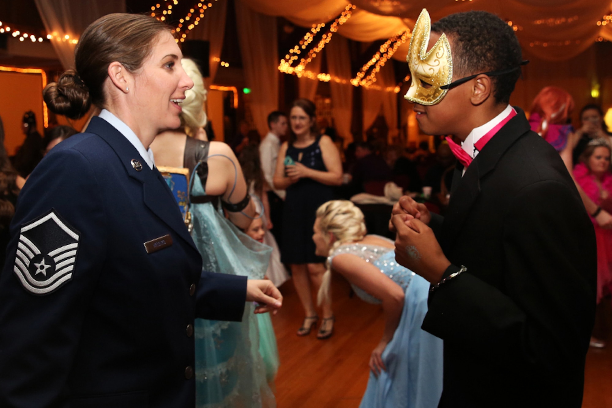 U.S. Air Force Master Sgt. Andre’ Menard, 707th Maintenance Squadron Training Manager, shares a light moment with a guest of honor at the Shriners’ Mardi Gras Ball, Shreveport, La., Feb. 24, 2017.   Menard and other members of the 307th Bomb Wing teamed up with the Shriners and  Margaritaville Resort and Casino, who sponsored the event, to provide children with special needs a night of fun and dancing.   In addition to serving as escorts for the party, members of the wing helped to provide gowns for the children.   (Courtesy photo/released)