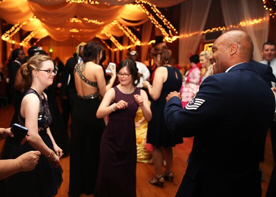 U.S. Air Force Tech. Sgt. Terance Thomas, 489th Maintenance Squadron crew chief, cuts a rug with honorees at the Shriners’ Mardi Gras Ball, Shreveport, La., Feb. 24, 2017. The children enjoyed a night of fun and dancing courtesy of Margaritaville Resort and Casino, the event sponsor. Airmen of the 307th Bomb Wing helped not only as escorts, but to provide dress gowns for the event.  (Courtesy photo/released)