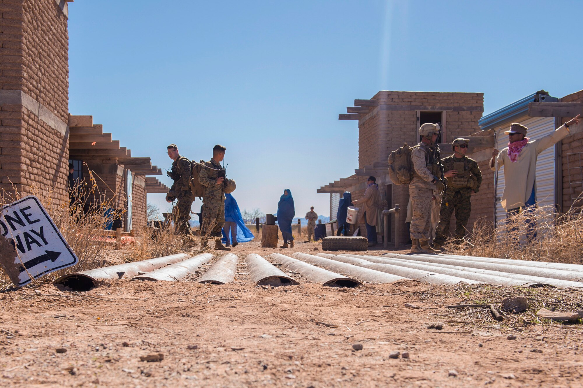 Marines from I Marine Expeditionary Force assigned to Marine Corps Base Camp Pendleton, Calif., communicate with mock friendly locals in a Southwest Asian bazaar in search of the whereabouts of downed aircrew members during a simulated Tactical Recovery of Aircraft and Personnel scenario, Feb 22, 2017, at the Playas Training and Research Center, N.M. During the scenario, the IMEF rescued isolated personnel from a downed aircraft while fending off mock opposition forces from Davis-Monthan Air Force Base, Ariz.’s 563d Operations Support Squadron. This joint effort prepared the IMEF by completing their Special Purpose Marine Air Ground Task Force certification. This is the culmination of their crisis response operations before deploying to the United States Central Command, which consists of 20 countries In Northeast Africa and Southwest Asia. (U.S. Air Force photo by Airman 1st Class Greg Nash)   