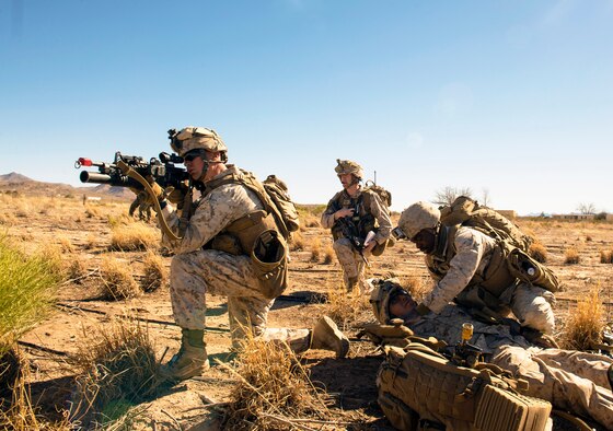 A Marine from the I Marine Expeditionary Force located at  Camp Pendleton, Calif., fends off enemy fire as his counterpart assesses a casualty during a simulated Tactical Recovery of Aircraft and Personnel scenario, Feb. 22, 2017, at the Playas Training and Research Center, N.M. During the scenario, the I MEF rescued isolated personnel from a downed aircraft while fending off mock opposition forces from the 563rd Operations Support Squadron, Davis-Monthan Air Force Base, Ariz. (U.S. Air Force photo/Airman 1st Class Greg Nash)