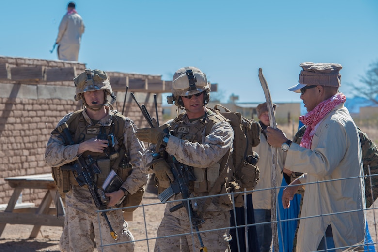 A Marine from the I Marine Expeditionary Force assigned to Marine Corps Base Camp Pendleton, Calif., asks a mock Southwest Asian local in a bazaar about the whereabouts of a downed aircrew during a simulated Tactical Recovery of Aircraft and Personnel scenario, Feb 22, 2017, at the Playas Training and Research Center, N.M. During the scenario, the IMEF rescued isolated personnel from a downed aircraft while fending off mock opposition forces from Davis-Monthan Air Force Base, Ariz.’s 563d Operations Support Squadron. This joint effort prepared the IMEF by completing their Special Purpose Marine Air Ground Task Force certification. This is the culmination of their crisis response operations before deploying to the United States Central Command, which consists of 20 countries In Northeast Africa and Southwest Asia. (U.S. Air Force photo by Airman 1st Class Greg Nash)   