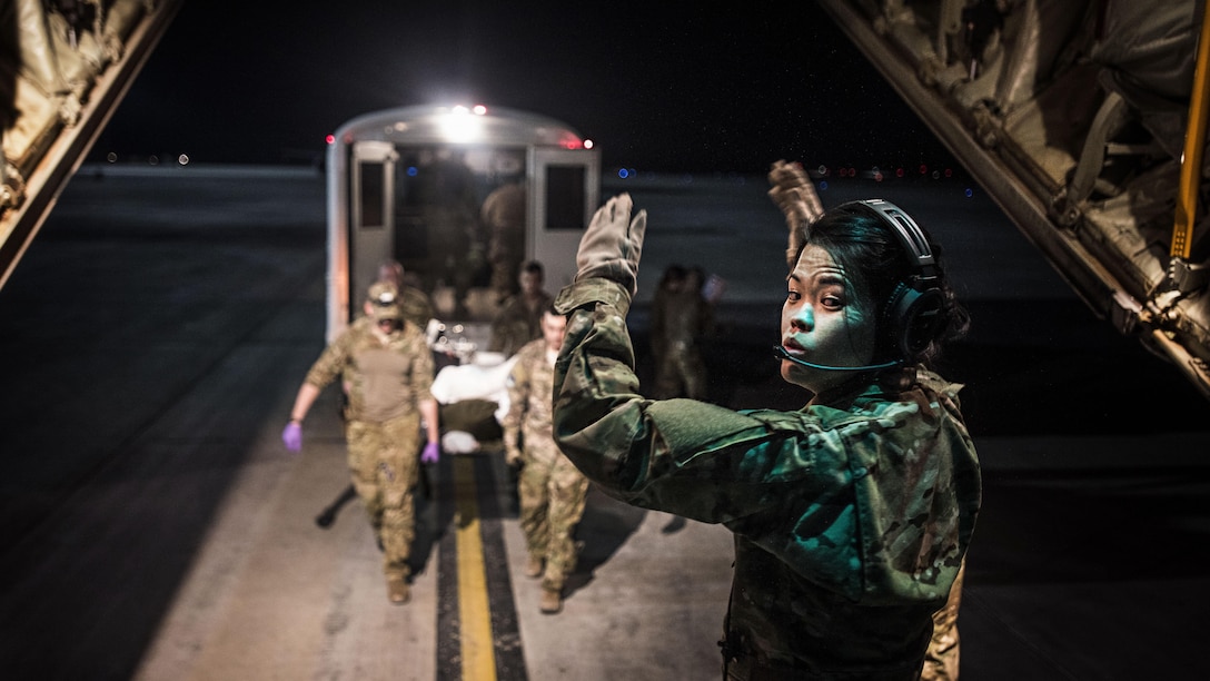 Air Force 1st Lt. Sarah Jun directs troops bringing a patient onto a C-130J Hercules for transport from a military hospital at Kandahar Airfield, Afghanistan, Feb. 22, 2017, to the Craig Joint Theater Hospital at Bagram Airfield, Afghanistan. Jun is a flight nurse assigned to the 455th Aeromedical Evacuation Squadron, which operates an intensive care unit aboard an aircraft to enable teams to transport critically injured or ill patients to a higher level of care. Air Force photo by Staff Sgt. Katherine Spessa