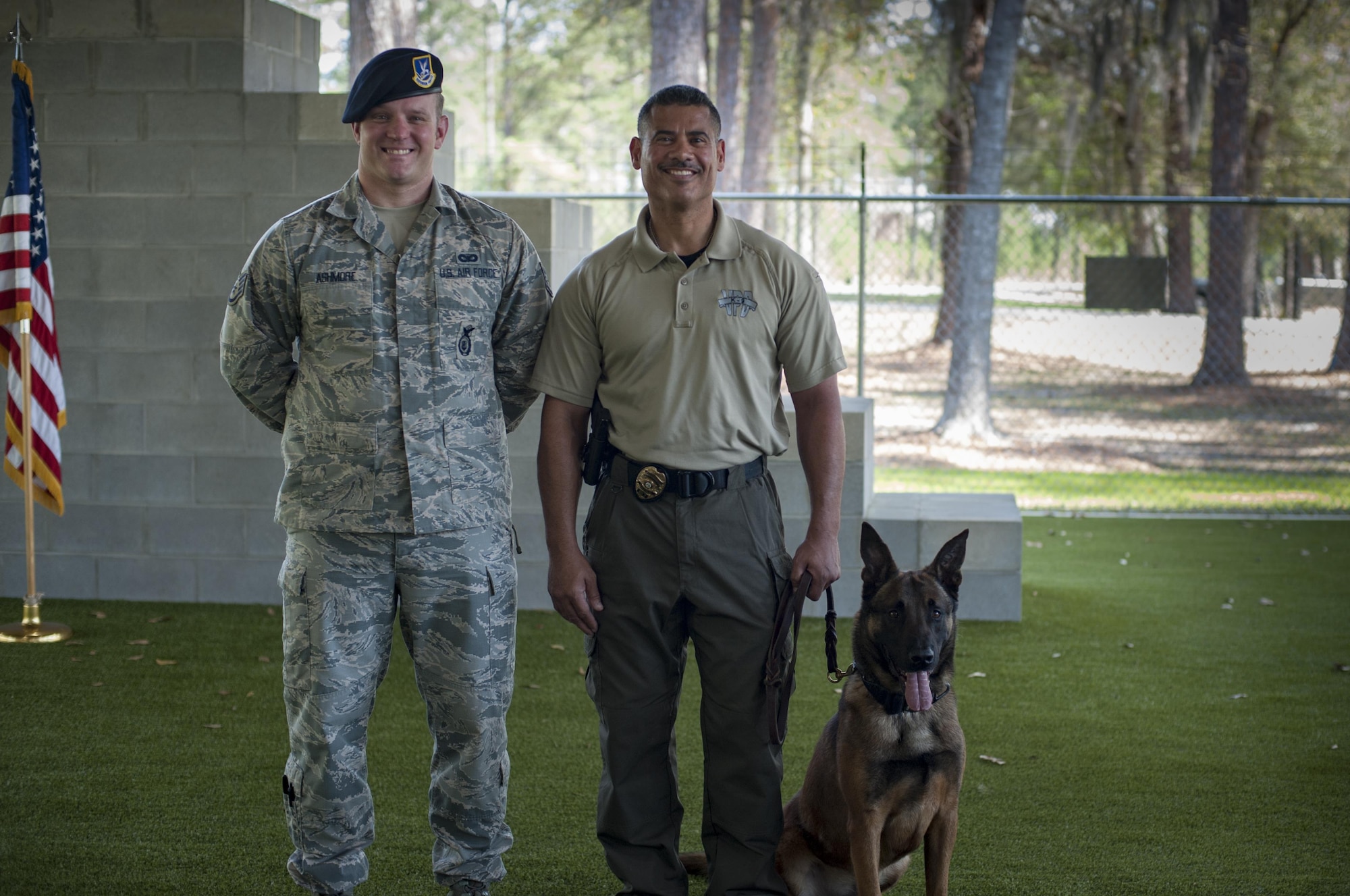 Staff Sgt. Jason Ashmore, 23d Security Forces Squadron military working dog trainer, left, Officer Jose Cruz, Valdosta Police Department K-9 handler, center, and MWD SSmokey pose for a photo during a MWD leash transfer ceremony, Feb. 28, 2017, at Moody Air Force Base, Ga. MWD Ssmokey was transferred from the care of Ashmore to Cruz, where he will continue his work as an explosive detective dog in the local community. (U.S. Air Force photo by Airman 1st Class Lauren M. Sprunk)