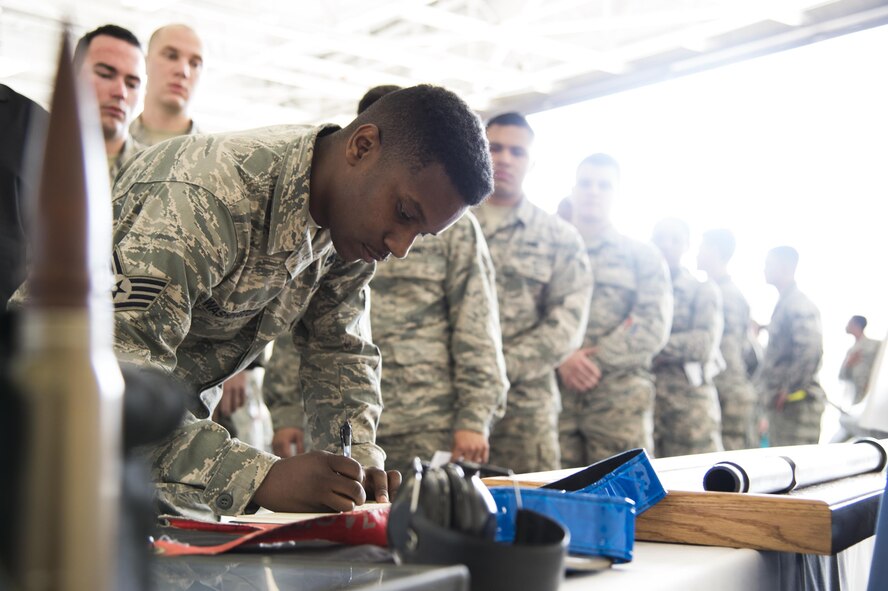 Staff Sgt. Tayrell Washington, 23d Maintenance Group weapons standardization lead crew team chief, signs a guestbook during a memorial ceremony in honor of Staff Sgt. Sara Toy, 74th Aircraft Maintenance Unit weapons team chief, March 1, 2017, at Moody Air Force Base, Ga. Toy, a New Kent, Virginia native, died in a car accident Feb. 25, 2017. During the ceremony, she was remembered as a valuable member of the Team Moody weapons community and was posthumously awarded the Air Force Commendation Medal and the rank of Staff Sergeant. (U.S. Air Force photo by Andrea Jenkins/Released)