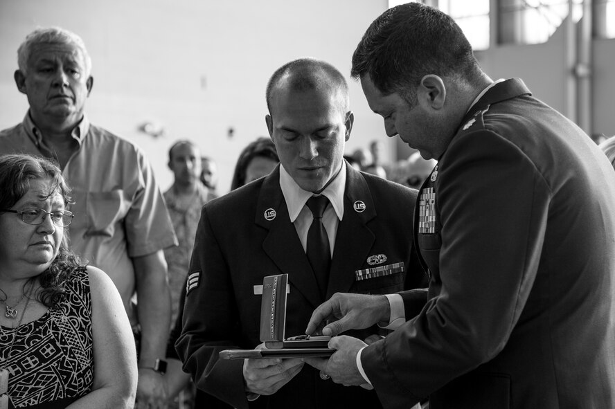 Lt. Col. Bobby Buckner, 23d Aircraft Maintenance Squadron commander, presents an Air Force Commendation Medal for the late Staff Sgt. Sara Toy, 74th Aircraft Maintenance Unit weapons team chief, to her husband Senior Airman Lucus Zeman, 23d Equipment Maintenance Squadron, during a memorial ceremony, March 1, 2017, at Moody Air Force Base, Ga. Toy, a New Kent, Virginia native, died in a car accident Feb. 25, 2017. During the ceremony, she was remembered as a valuable member of the Team Moody weapons community and was posthumously awarded the Air Force Commendation Medal and the rank of Staff Sergeant. (U.S. Air Force photo by Andrea Jenkins/Released)