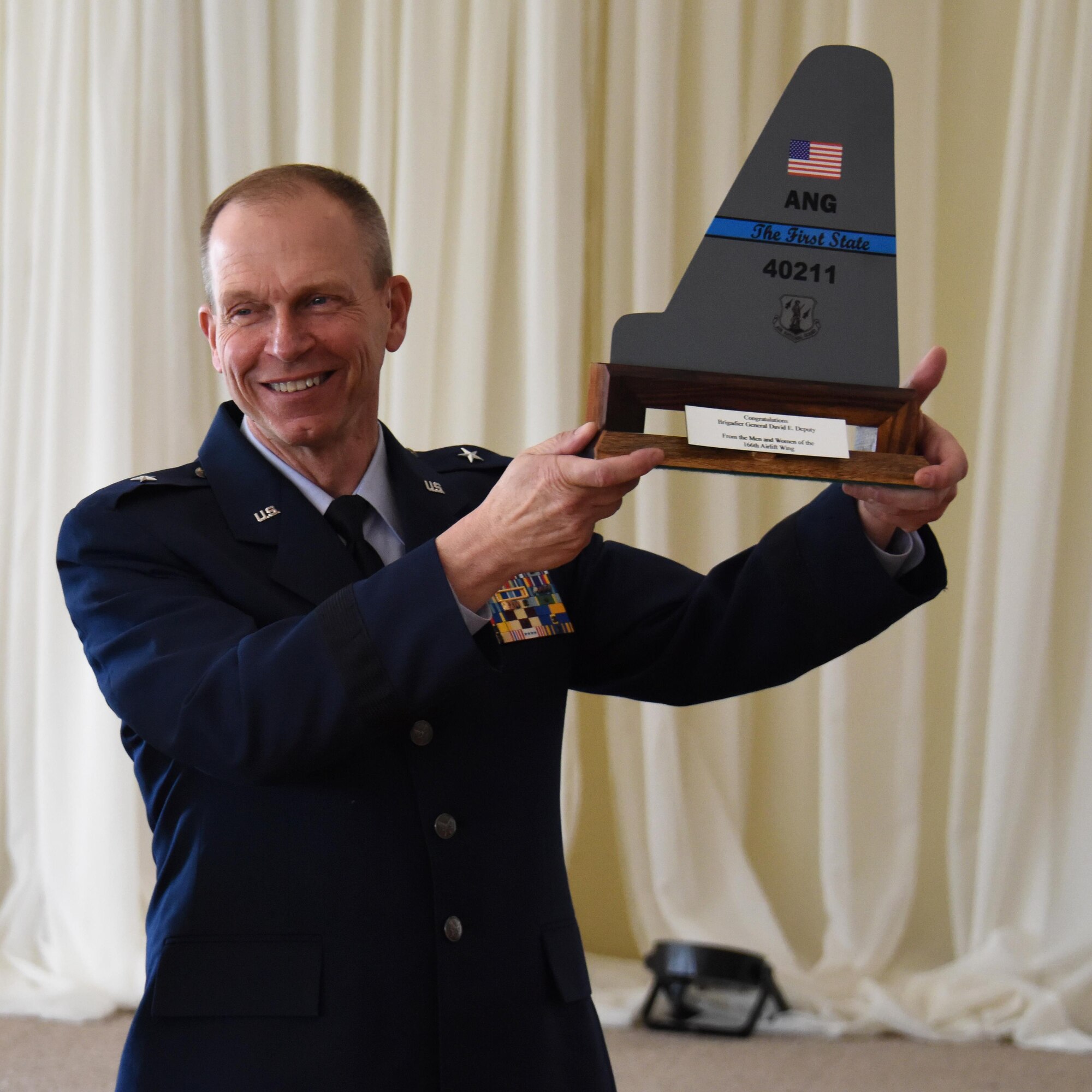 NEWARK, De.- Brig. Gen. David E. Deputy, chief of staff, Delaware National Guard, holds up a tail flash presented by Col. David B. Walker, assistant adjutant general-air, Delaware National Guard, during a luncheon held at the Cavalier Country Club, as a symbol of appreciation for over forty years of service in the Delaware Air National Guard. (U.S. Air National Guard photo by Tech. Sgt. Gwendolyn Blakley\ Released). 