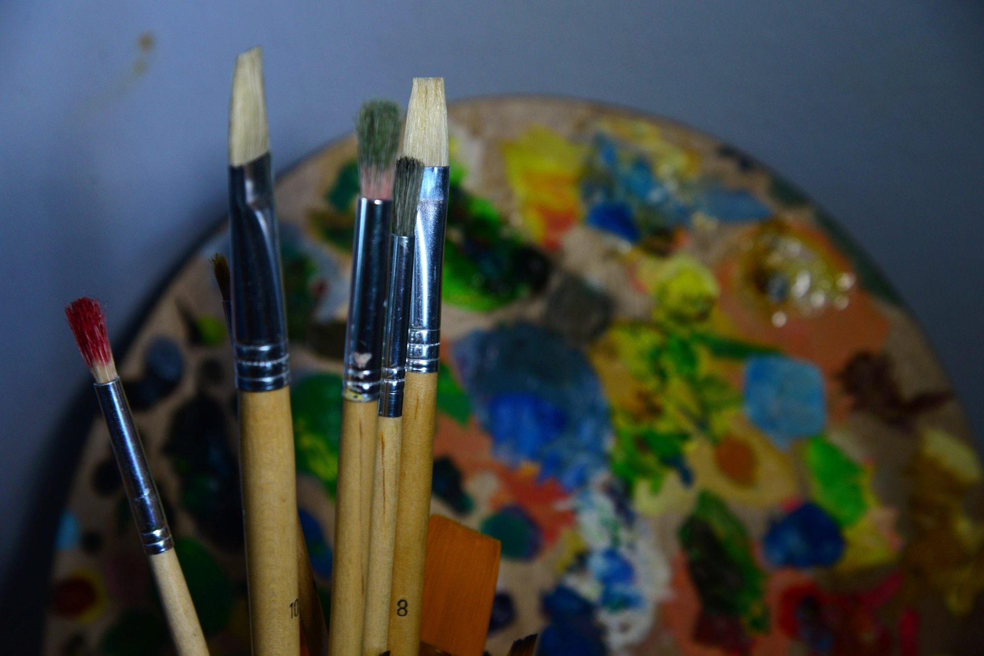 Airman 1st Class Yoli Alvarez Hernandez, 341st Medical Operations Squadron mental health technician, uses brushes and a painters wheel in her creative workplace Feb. 28, 2017, at the door complex at Malmstrom Air Force Base, Mont. An artist must can use brushes varying in bristle length and texture to paint works of art. (U.S. Air Force photo/Airman 1st Class Magen M. Reeves)