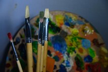 Airman 1st Class Yoli Alvarez Hernandez, 341st Medical Operations Squadron mental health technician, uses brushes and a painters wheel in her creative workplace Feb. 28, 2017, at the door complex at Malmstrom Air Force Base, Mont. An artist must can use brushes varying in bristle length and texture to paint works of art. (U.S. Air Force photo/Airman 1st Class Magen M. Reeves)
