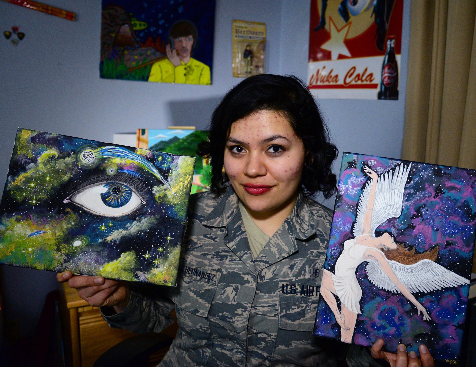 Airman 1st Class Yoli Alvarez Hernandez, 341st Medical Operations Squadron mental health technician, holds some of her artwork in her dorm room Feb. 28, 2017, at Malmstrom Air Force Base, Mont. Alvarez Hernandez paints in her spare time and likes to hang her creations on her walls to make her dorm room feel more like home. (U.S. Air Force photo/Airman 1st Class Magen M. Reeves)