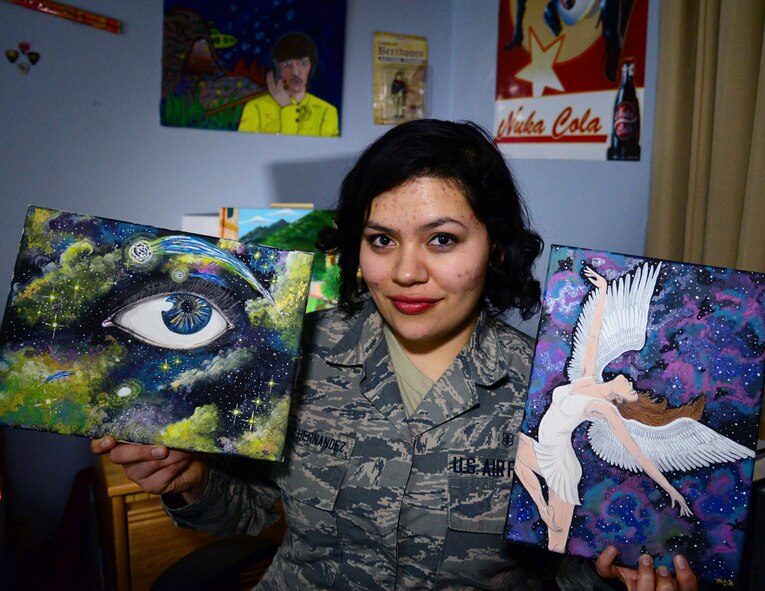 Airman 1st Class Yoli Alvarez Hernandez, 341st Medical Operations Squadron mental health technician, holds some of her artwork in her dorm room Feb. 28, 2017, at Malmstrom Air Force Base, Mont. Alvarez Hernandez paints in her spare time and likes to hang her creations on her walls to make her dorm room feel more like home. (U.S. Air Force photo/Airman 1st Class Magen M. Reeves)