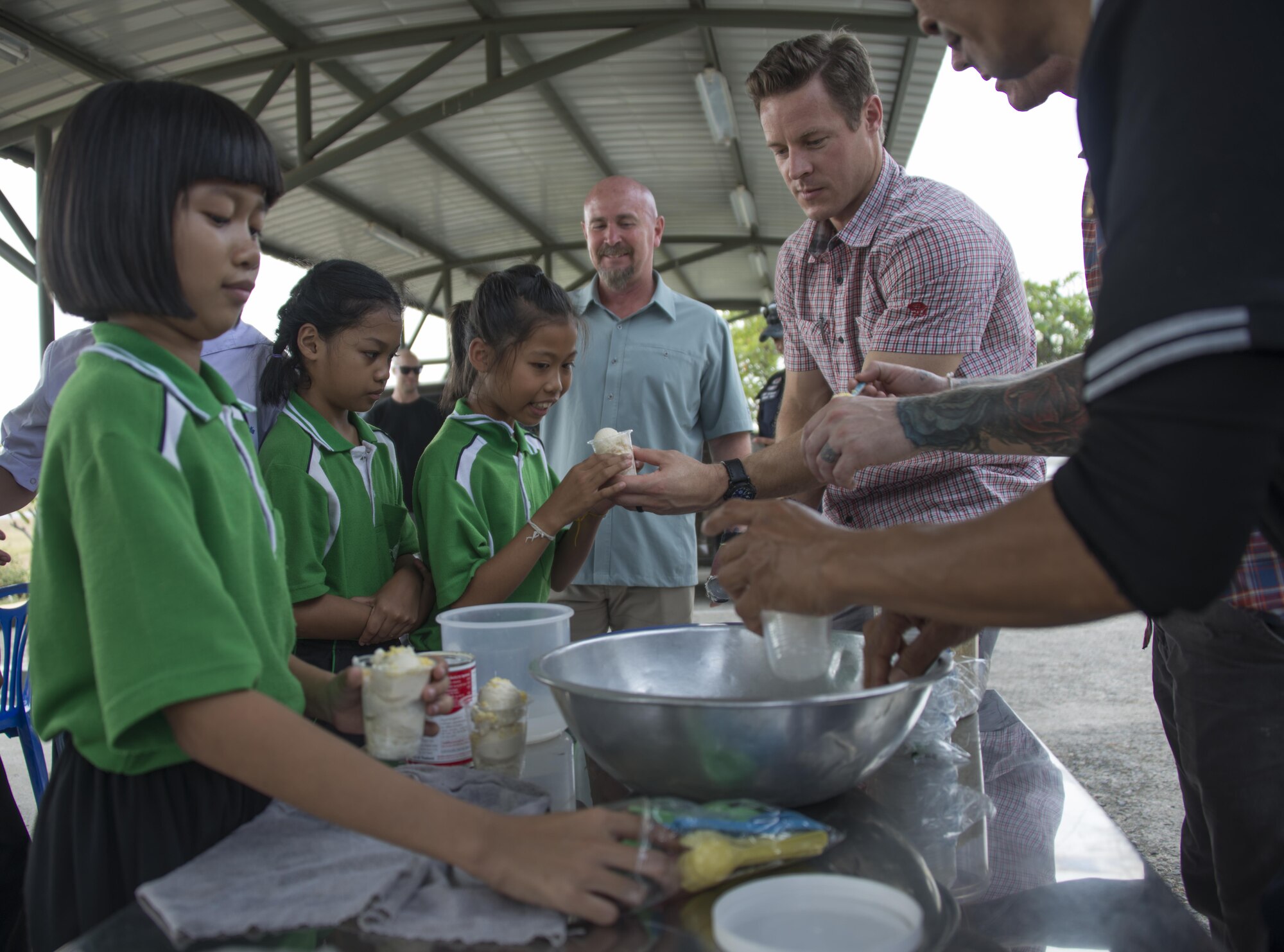 U.S. Air Force Maj. Joel Buelow, 353rd Special Operations Group mission commander for Cobra Gold 2017, serves ice cream to Thai students from Sirijantaranmit School Lopburi during a community relations event, Feb. 23, 2017. In addition to engaging with the students, the military members supported the school with a $4,000 donation of computers and school supplies. (U.S. Air Force photo by Capt. Jessica Tait)