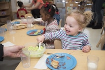 Addelyn, daughter of Tech. Sgt. Shannon Hutto, the swings flight chief with the 35th Security Forces Squadron, takes a serving of green eggs as part of the Child Development Center celebration for Read Across America at Misawa Air Base, Japan, March 2, 2017. Read Across America is an annual reading, motivation and awareness program created by the National Education Association group. (U.S. Air Force photo by Staff Sgt. Melanie A. Hutto)