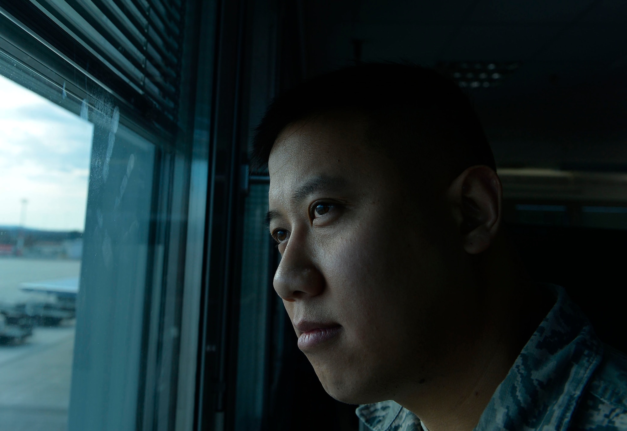Staff Sgt. Srun Sookmeewiriya, 313th Expeditionary Operations Support Squadron NCO in charge of reports, stares out the window of his work center on Ramstein Air Base, Germany, Feb. 16, 2017. Sookmeewiriya attempted suicide twice after the death of both his parents. He now shares his story in an effort to help Airmen open up about struggles and bounce back from their challenges. (U.S. Air Force photo by Airman 1st Class Joshua Magbanua)