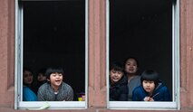 A family peer out their house windows at a parade during fasching, a festival held across Europe, in the city of Ramstein, Germany, Feb. 28, 2017. During modern fasching, people parade around cities to welcome the new season while saying goodbye to winter. (U.S. Air Force photo by Senior Airman Lane T. Plummer)