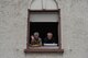 Two elderly people peer out their house window during fasching, a festival held across Europe, in the city of Ramstein, Germany, Feb. 28, 2017. The festival season is celebrated by people from Germany, Switzerland and Austria. (U.S. Air Force photo by Senior Airman Lane T. Plummer)