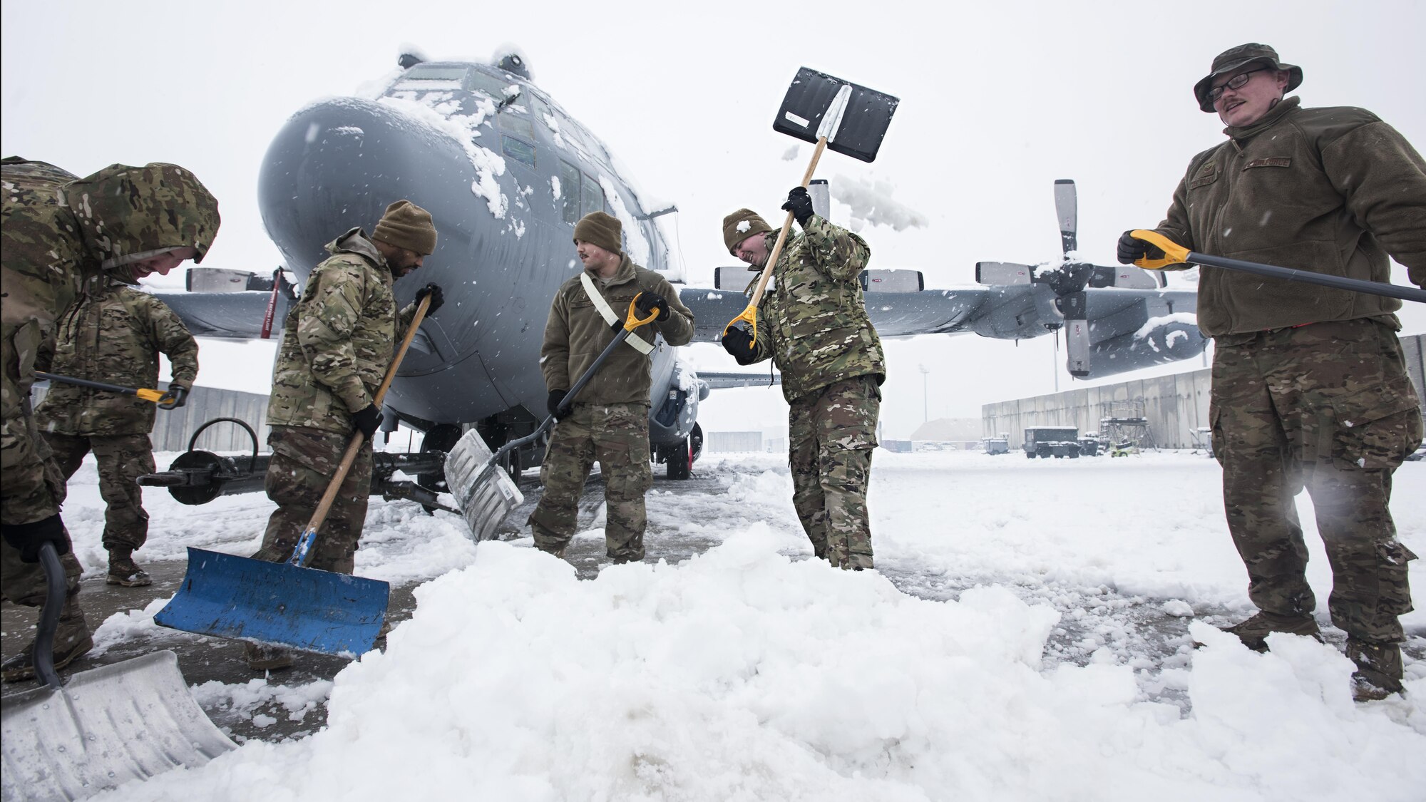 Members of the 455th Expeditionary Aircraft Maintenance Squadron EC-130 Compass Call Aircraft Maintenance Unit shovel snow from under their aircraft at Bagram Airfield, Afghanistan Feb. 4, 2017. The unit ensured their aircraft were cleared of snow to return to the mission after the base got several inches of snowfall. (U.S. Air Force photo by Staff Sgt. Katherine Spessa)