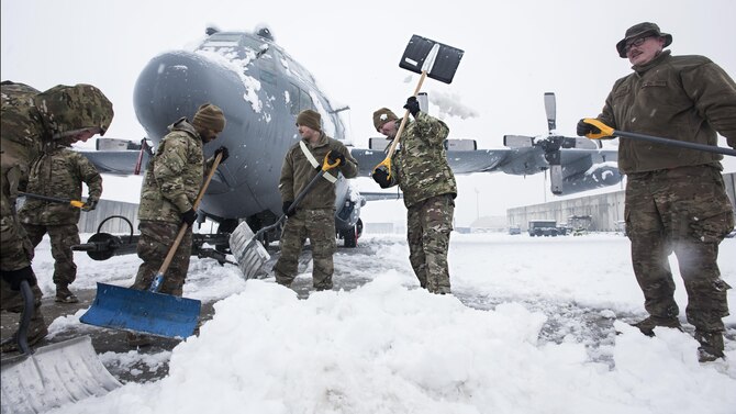 Members of the 455th Expeditionary Aircraft Maintenance Squadron EC-130 Compass Call Aircraft Maintenance Unit shovel snow from under their aircraft at Bagram Airfield, Afghanistan Feb. 4, 2017. The unit ensured their aircraft were cleared of snow to return to the mission after the base got several inches of snowfall. (U.S. Air Force photo by Staff Sgt. Katherine Spessa)