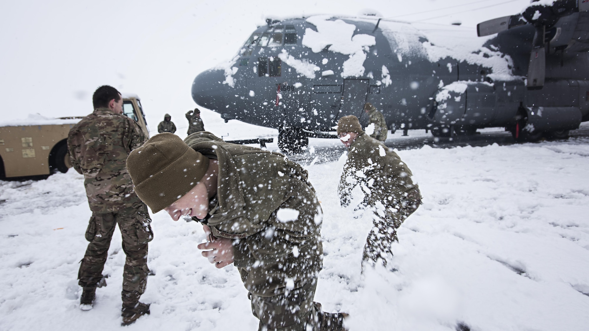 Members of the 455th Expeditionary Aircraft Maintenance Squadron EC-130 Compass Call Aircraft Maintenance Unit have a snowball fight after shoveling snow from under their aircraft at Bagram Airfield, Afghanistan Feb. 4, 2017. The unit ensured their aircraft were cleared of snow to return to the mission after the base got several inches of snowfall. (U.S. Air Force photo by Staff Sgt. Katherine Spessa)