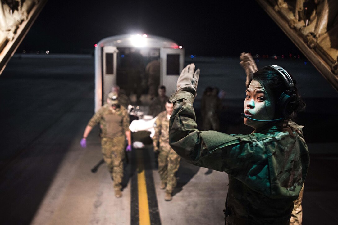 Air Force 1st Lt. Sarah Jun directs troops bringing a patient onto a C-130J Hercules for transport from a military hospital at Kandahar Airfield, Afghanistan, to the Craig Joint Theater Hospital at Bagram Airfield, Afghanistan, Feb. 22, 2017. Jun is a flight nurse assigned to the 455th Aeromedical Evacuation Squadron, which operates an intensive care unit aboard an aircraft to enable teams to transport critically injured or ill patients to a higher level of care. Air Force photo by Staff Sgt. Katherine Spessa