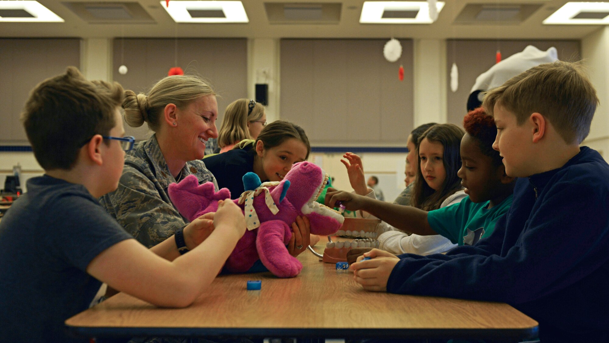 Maj Rachel Weber, 31st Dental Squadron Periodontist, educates children on proper brushing and flossing techniques, Feb. 15, 2017, at Aviano Air Base, Italy. Airmen from the 31st DS visited the elementary school, child development centers and library for Children’s Dental Health Month. (U.S. Air Force photo by Senior Airman Cary Smith)