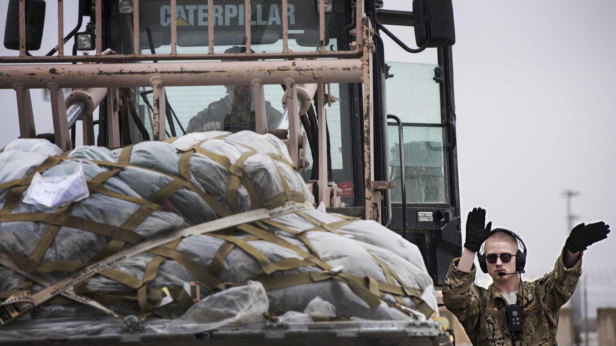 Senior Airman Brandon King, 774th Expeditionary Airlift Squadron loadmaster, directs cargo-loading onto a C-130J Hercules at Herat, Afghanistan, Feb. 17, 2017. The 774th EAS and their contingent of C-130 aircraft is based out of Dyess Air Force Base, Texas, along with the 455th EAMXS’s C-130 aircraft maintenance unit. (U.S. Air Force photo by Staff Sgt. Katherine Spessa)