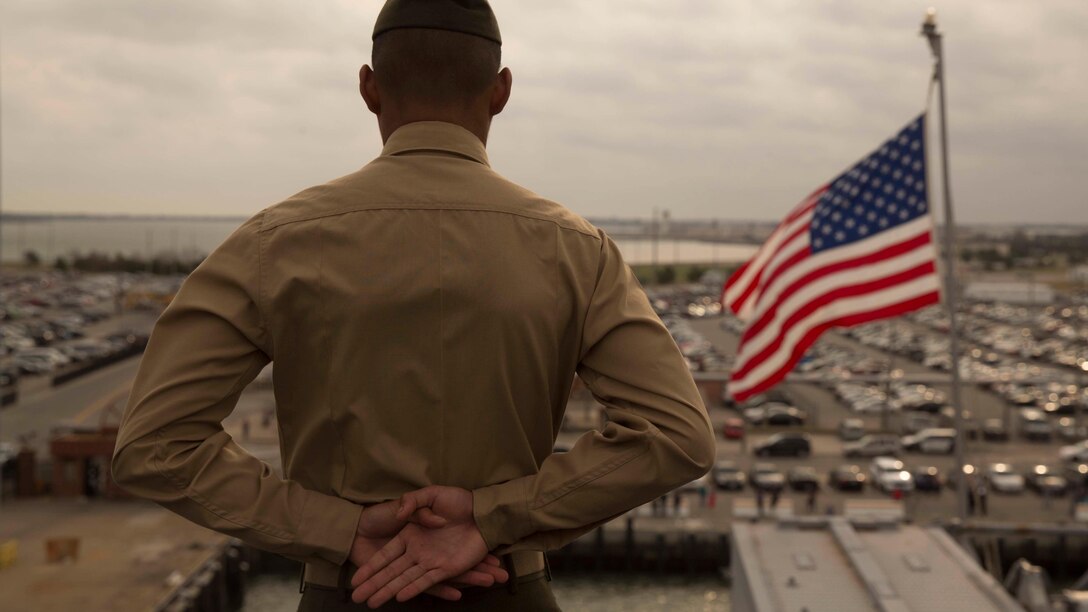 A Marine with the 24th Marine Expeditionary Unit mans the rails as amphibious assault ship USS Bataan (LHD 5) prepares to go underway for deployment March 1, 2017. The 24th MEU will operate in Europe and the Middle East in the coming months providing crisis response and contingency support for combatant commanders, including maritime security operations, humanitarian assistance, and advance force operations.