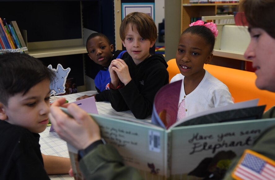 Ramstein Elementary School students listen to Capt. Charity Bolling, 86th Aerospace Medicine Squadron flight commander, read a book during the Seuss Café Reading at Ramstein Air Base, Germany, March 3, 2017.  More than 50 service members volunteered to read a combined 20 hours to the students during the week-long event. (U.S. Air Force photo by Staff Sgt. Nesha Humes)