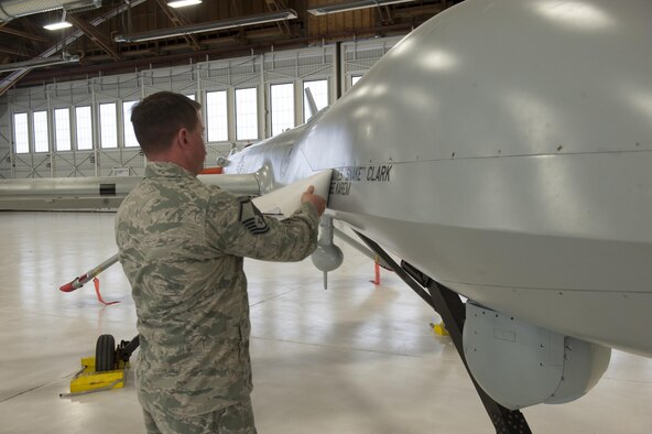 An Airman unveils James G. Clark, the Director of Intelligence, Surveillance, and Reconnaissance Modernization and Infrastructure; Deputy Chief of Staff for ISR, and Abraham Karem, the founding father of the unmanned aerial vehicle technology and designer of the Predator, names on the static MQ-1 Predator at a ceremony that will be displayed in Heritage Park at Holloman Air Force Base, N.M., Feb. 27, 2017. The MQ-1 Predator has provided many years of service and is being phased out of service as the Air Force transitions to the more capable MQ-9 Reaper. The MQ-1 Predator is an armed, multi-mission, medium-altitude, long-endurance remotely piloted aircraft that is employed primarily as an intelligence-collection asset and secondarily against dynamic execution targets. (U.S Air Force photo/Airman Ilyana A. Escalona)