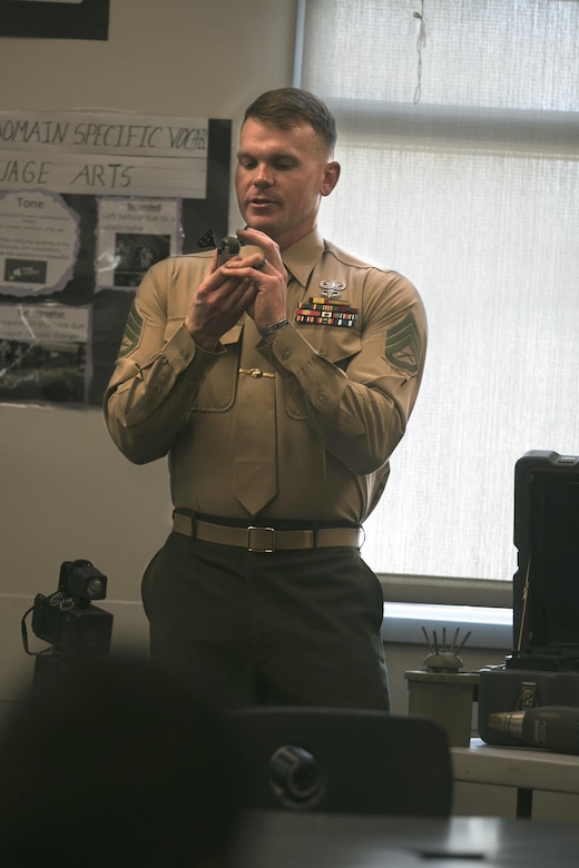 Staff Sgt. Robert Bouchard,  explosive ordnance disposal technician, explains how an inert munition works at Painted Hills Middle School during a career day in Desert Hot Springs, Calif., Feb. 23, 2017. The purpose of the visit was to further the installations commitment to the community and help inspire children to begin thinking about their future.  (Official Marine Corps Photo by Cpl. Julio McGraw/Released)