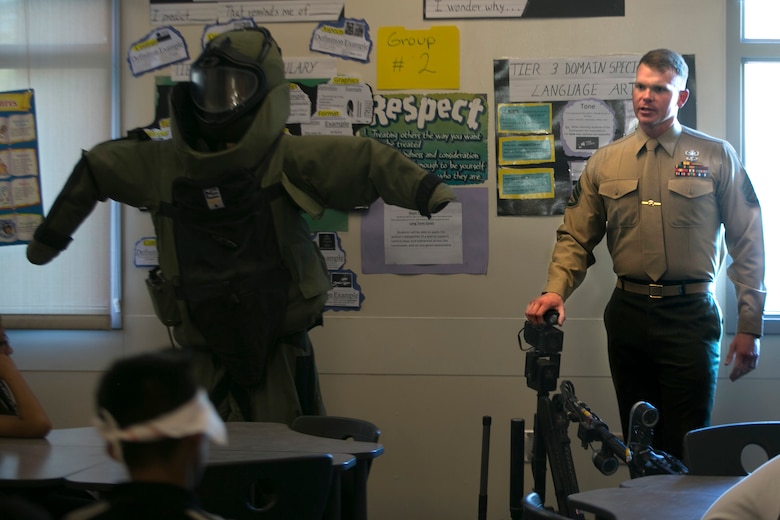 Staff Sgt. Robert Bouchard,  explosive ordnance disposal technician, answers Painted Hills Middle School students question during a career day in Desert Hot Springs, Calif., Feb. 23, 2017. The purpose of the visit was to further the installations commitment to the community and help inspire children to begin thinking about their future.  (Official Marine Corps Photo by Cpl. Julio McGraw/Released)
