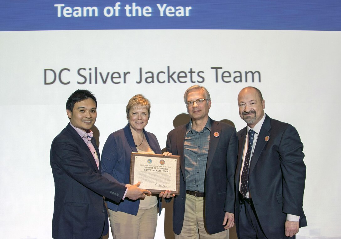 From left, Phetmano Phannavong, DC Department of Energy and Environment, DC floodplain manager; Stacey Underwood, U.S. Army Corps of Engineers, Baltimore District, Silver Jackets Program coordinator; and Mark Baker, National Park Service, Dam and Levee Safety officer, are recognized as part of the District of Columbia Silver Jackets Team as state Silver Jackets team of the year, during the 2017 Interagency Flood Risk Management Workshop in St. Louis, March 2, 2017. Mark Roupas (at right), Corps, Office of Homeland Security deputy chief, presented the team members with the award during the workshop. The Corps Baltimore District, NPS and DOEE jointly lead the DC Silver Jackets, which is an interagency team that manages flood risks in the District. There are active Silver Jackets teams in 47 states, plus the District, and the program is sponsored by the Corps. (Courtesy photo) 