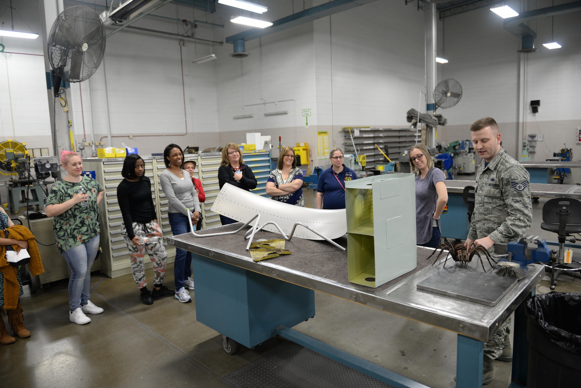Staff Sgt. Konrad Jazwierski, 55th Maintenance Squadron aircraft structural maintenance technician, shows 55th MXS spouses the sheet metal shop in the Bennie L. Davis Maintenance Facility at Offutt Air Force Base, Neb., Feb. 17, 2017. Members of the 55th MXS had a chance to show their spouses what they do for the Air Force.(U.S. Air Force photo by Zachary Hada)