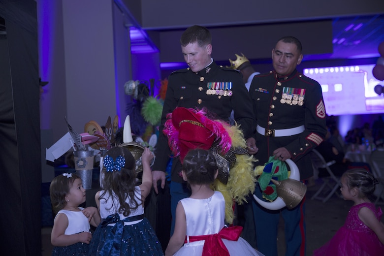 Marines are offered hats by their daughters during the annual Father Daughter Dance at building 1707 aboard Marine Corps Air Ground Combat Center, Twentynine Palms, Calif., Feb. 25, 2017. Marine Corps Community Services hosted the event to provide an opportunity for Marines and sailors to spend time with their daughters. (U.S. Marine Corps photo by Cpl. Medina Ayala-Lo)