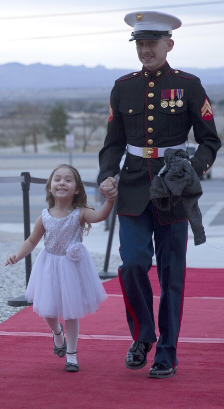 Cpl. Justin Falcon, automotive organizational mechanic, 7th Marine Regiment, escorts his daughter, Madelyn, 4, into the reception hall of the annual Father Daughter Dance at building 1707 aboard Marine Corps Air Ground Combat Center, Twentynine Palms, Calif., Feb. 25, 2017. Marine Corps Community Services hosted the event to provide an opportunity for Marines and sailors to spend time with their daughters. (U.S. Marine Corps photo by Cpl. Medina Ayala-Lo)