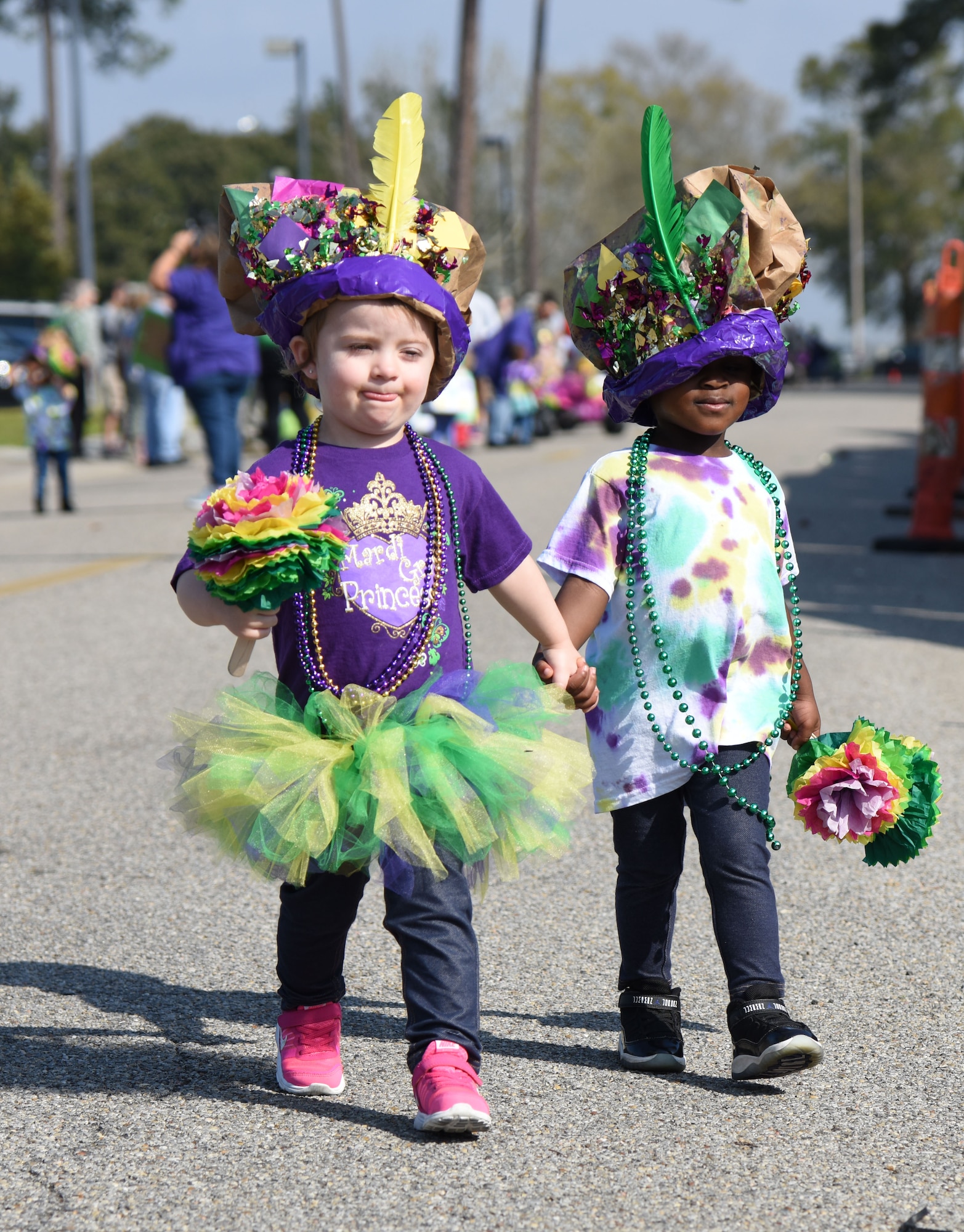 Aubrey Messerschmidt, daughter of Staff Sgt. Ruth Messerschmidt, 81st Surgical Operations Squadron general surgery clinic NCO in charge, and Ariah Lambert, daughter of Senior Airman Mia Lambert, 81st Medical Operations Squadron medical technician, walk hand in hand during the Keesler Child Development Center Mardi Gras parade Feb. 28, 2017, on Keesler Air Force Base, Miss. More than 300 children participated in the event, which started in 2009. (U.S. Air Force photo by Kemberly Groue)