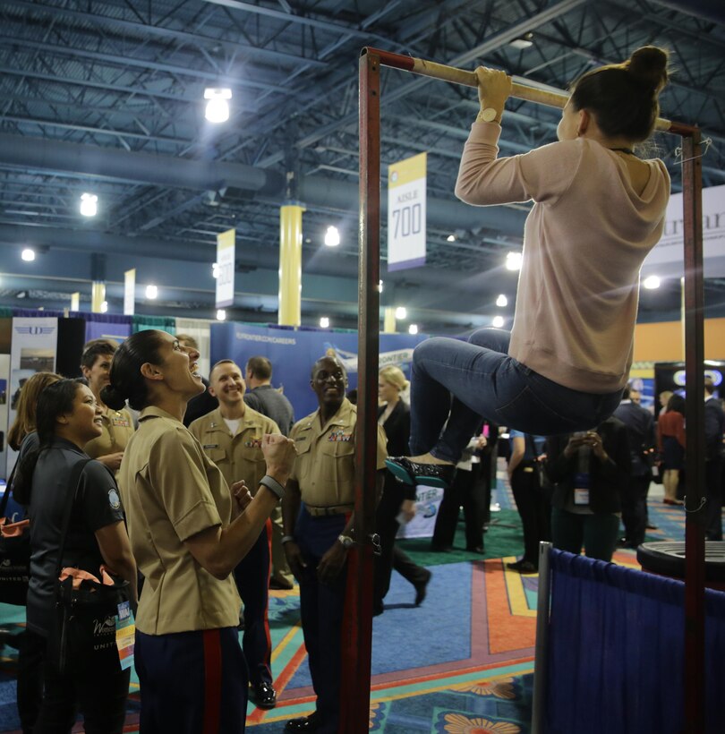 Marines motivate and cheer on an attendee of the 2017 Women in Aviation International Symposium in Orlando, Fla., March 2, 2017. The symposium is scheduled from 2-4 March, and allows Marines to interact with young men and women interested in aviation career paths, and to teach them about the many programs the Marine Corps has to offer them.