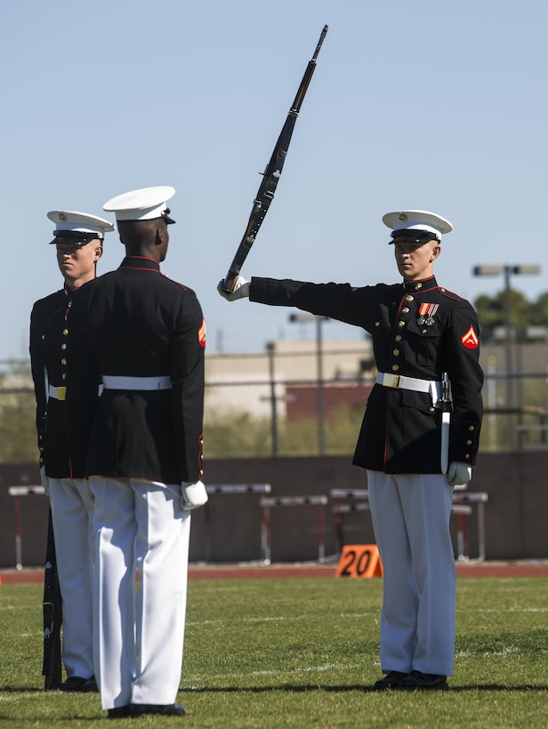 Corporal Jesse Thorton, number two rifle inspector, Marine Corps Silent Drill Platoon, and Lance Cpl. Ryan Watkins, rifle inspection team, Marine Corps Silent Drill Platoon, execute a rifle inspection during their first performance as a part of the U.S. Marine Corps Battle Color Detachment (BCD) performance tour at Kofa High School, Yuma, Az., Mar. 1, 2017. The BCD is comprised of the Marine Corps Silent Drill Platoon, “The Commandant’s Own,” the United States Marine Drum & Bugle Corps and the Marine Corps Color Guard. The Marines of this highly skilled unit travel across the country to demonstrate the discipline, professionalism, and “Esprit de Corps” of United States Marines. (Official Marine Corps photo by Cpl. Robert Knapp/Released)