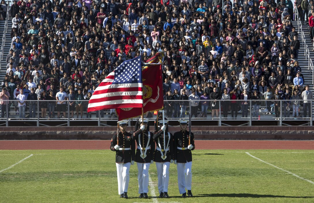 The Marine Corps Color Guard Marines present the national flag and the Marine Corps battle colors during their first performance as a part of the U.S. Marine Corps Battle Color Detachment (BCD) performance tour at Kofa High School, Yuma, Az., Mar. 1, 2017. The BCD is comprised of the Marine Corps Silent Drill Platoon, “The Commandant’s Own,” the United States Marine Drum & Bugle Corps and the Marine Corps Color Guard. The Marines of this highly skilled unit travel across the country to demonstrate the discipline, professionalism, and “Esprit de Corps” of United States Marines. (Official Marine Corps photo by Cpl. Robert Knapp/Released)