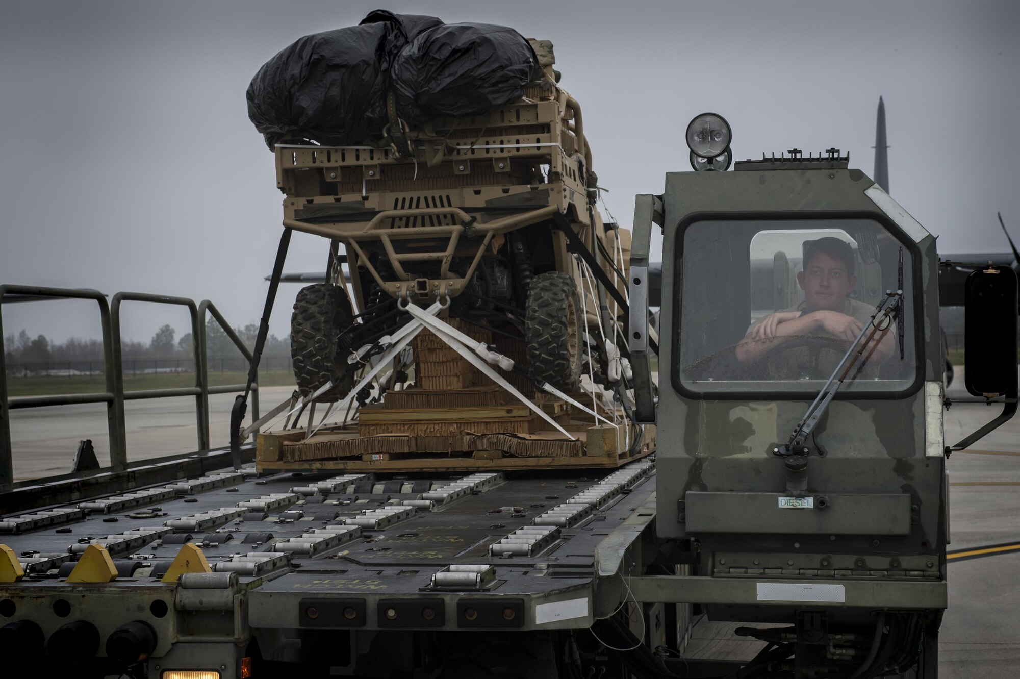 An Airman waits to load a military RZR all-terrain vehicle onto an HC-130J Combat King II, before a vehicle drop exercise, March 1, 2017, at Moody Air Force Base, Ga.  This was the first time the 38th Rescue Squadron dropped a MRZR and a significant feat as it landed on target, with no damage or discrepancies. (U.S. Air Force photo by Tech. Sgt. Zachary Wolf)
