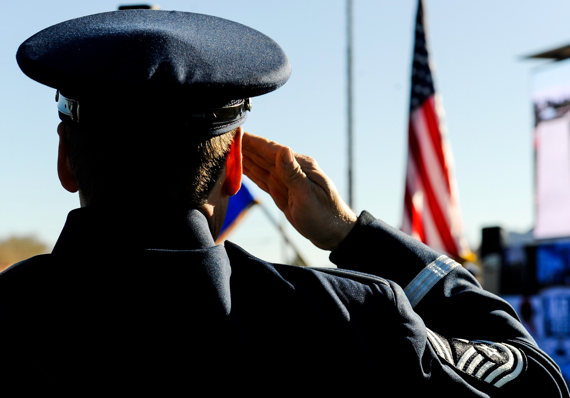A member of the Air Force Band salutes the American Flag during the playing of the national anthem at the 2017 Air Force Wounded Warrior Trials opening ceremony on Nellis Air Force Base, Nev., Feb. 24, 2017.The Air Force Wounded Warrior Program is a Congressionally-mandated and federally-funded program that provides personalized care, services and advocacy to wounded, ill or injured recovering service members. (U.S. Air Force photo by Airman 1st Class Kevin Tanenbaum/Released)
