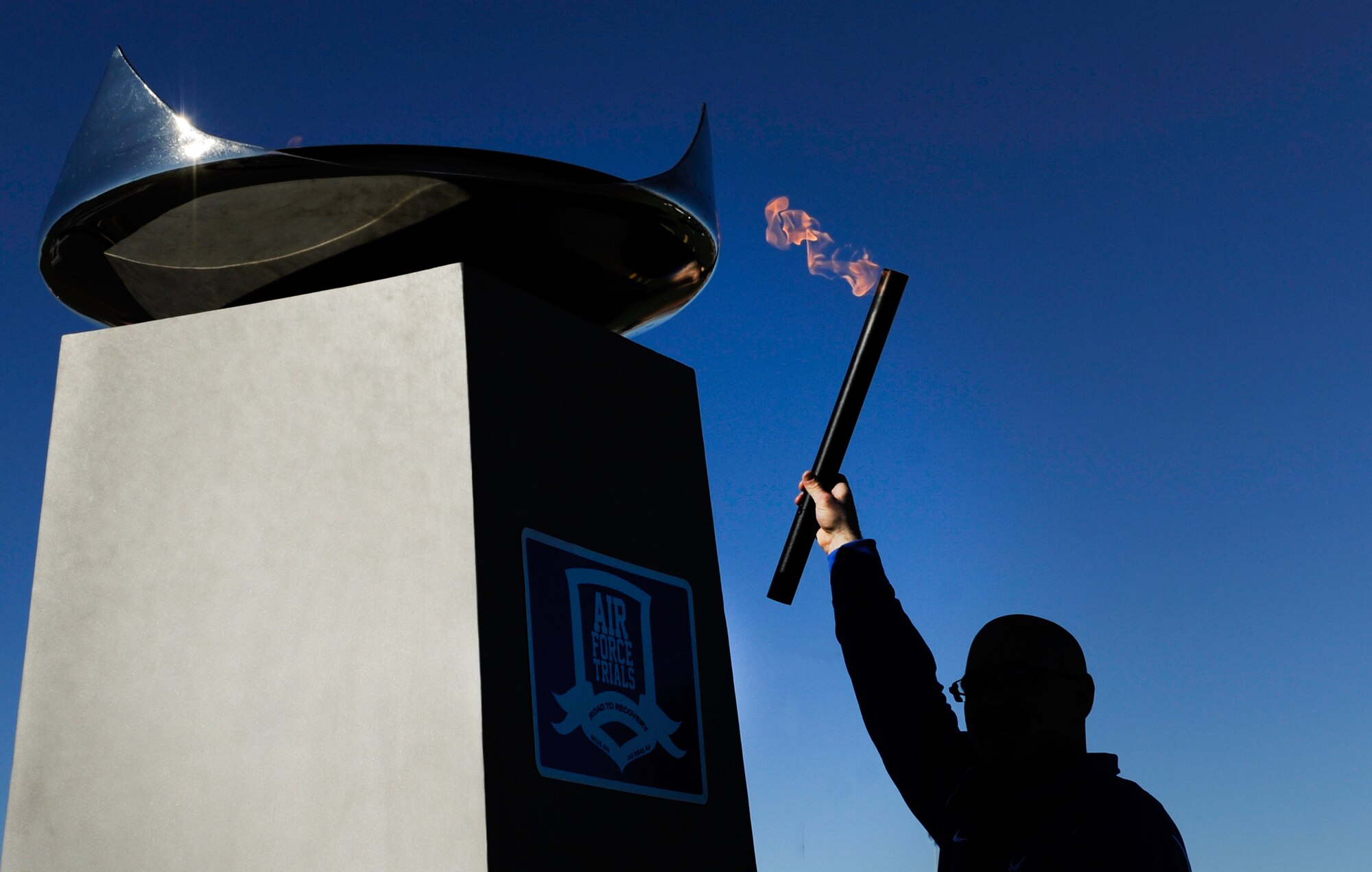 A competitor lights the flame during the 2017 Air Force Wounded Warrior Trials opening ceremony on Nellis Air Force Base, Nev., Feb. 24, 2017. More than 100 wounded, ill or injured service members from around the country, along with their support teams, have gathered for the Trials. (U.S. Air Force photo by Airman 1st Class Kevin Tanenbaum/Released)