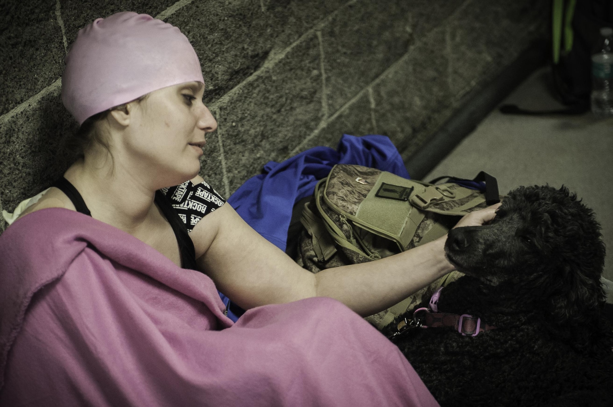 Ashley Crites, Air Force Wounded Warrior Trials competitor, and her service dog wait in between events during the swimming competition of the AFW2 at the University of Nevada Las Vegas pool, Feb. 26, 2017. Service dogs are a type of assistance dog that are used for people who have disabilities besides hearing and sight impairment, or other medical response dogs. (U.S. Air Force photo by Airman 1st Class Kevin Tanenbaum/Released)