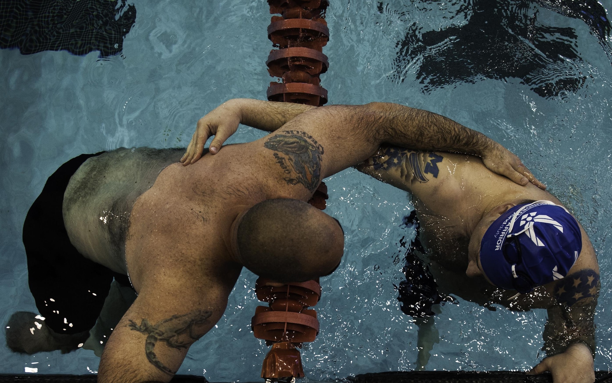 Two Air Force Wounded Warrior Trials competitors embrace after finishing the men’s 50 meter freestyle during the AFW2 at the University of Nevada Las Vegas pool, Feb. 26, 2017. The Air Force Trials are an adaptive sports event designed to promote the mental and physical well-being of seriously ill and injured military members and veterans. (U.S. Air Force photo by Airman 1st Class Kevin Tanenbaum/Released)
